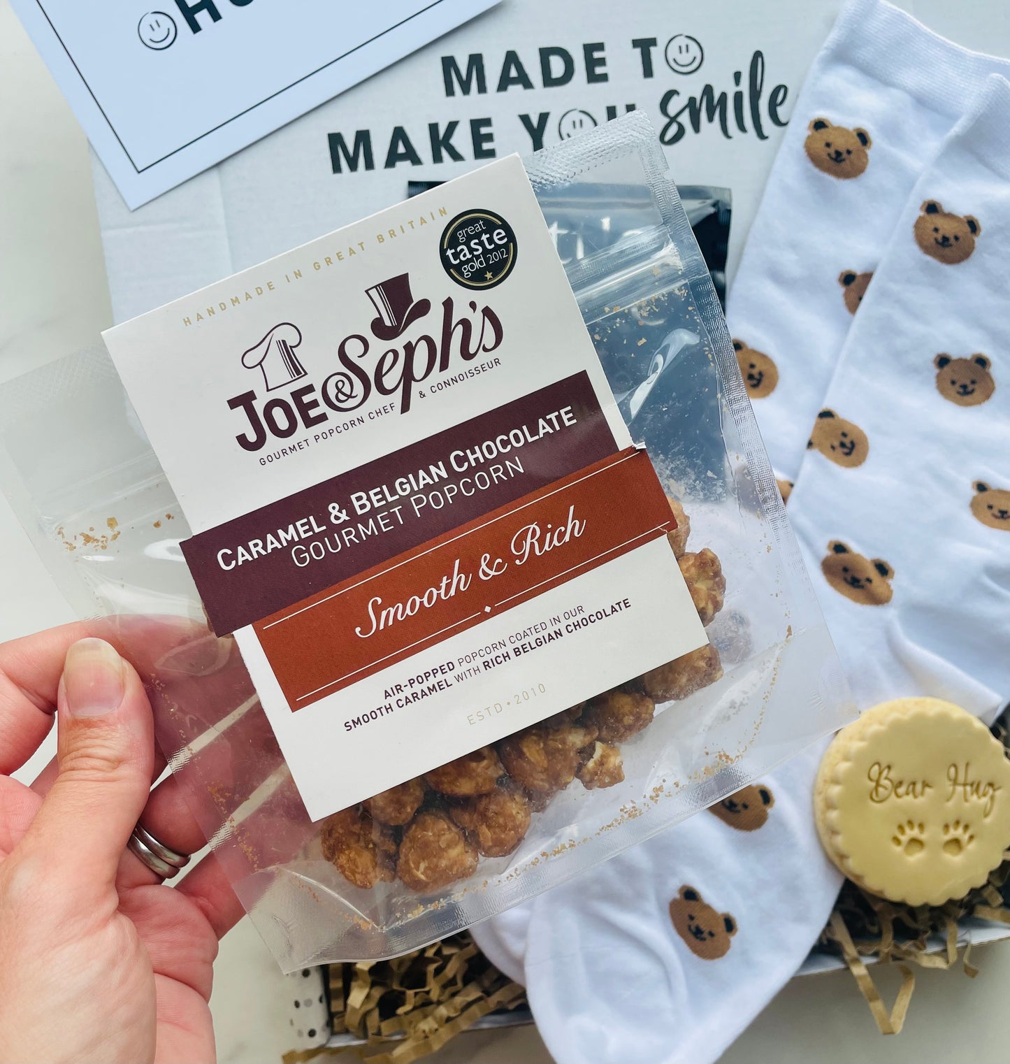 Packaged gourmet popcorn with Joe Seph's label, surrounded by bear-themed items.