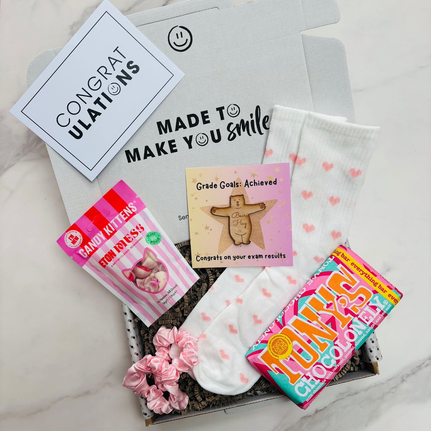 Gift set with socks, cards, and a scrunchie on a marble surface