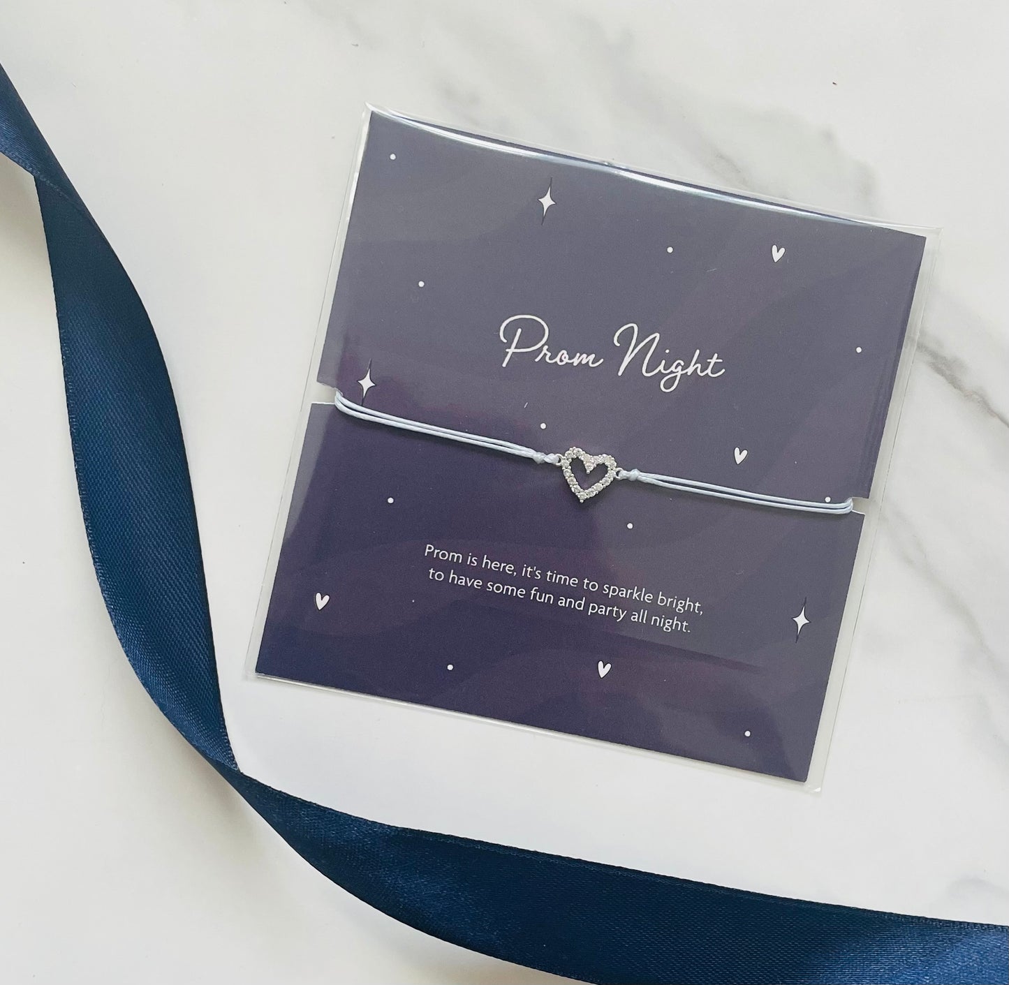 Bracelet with heart charm in clear packaging labeled 'Prom Night' on a white background