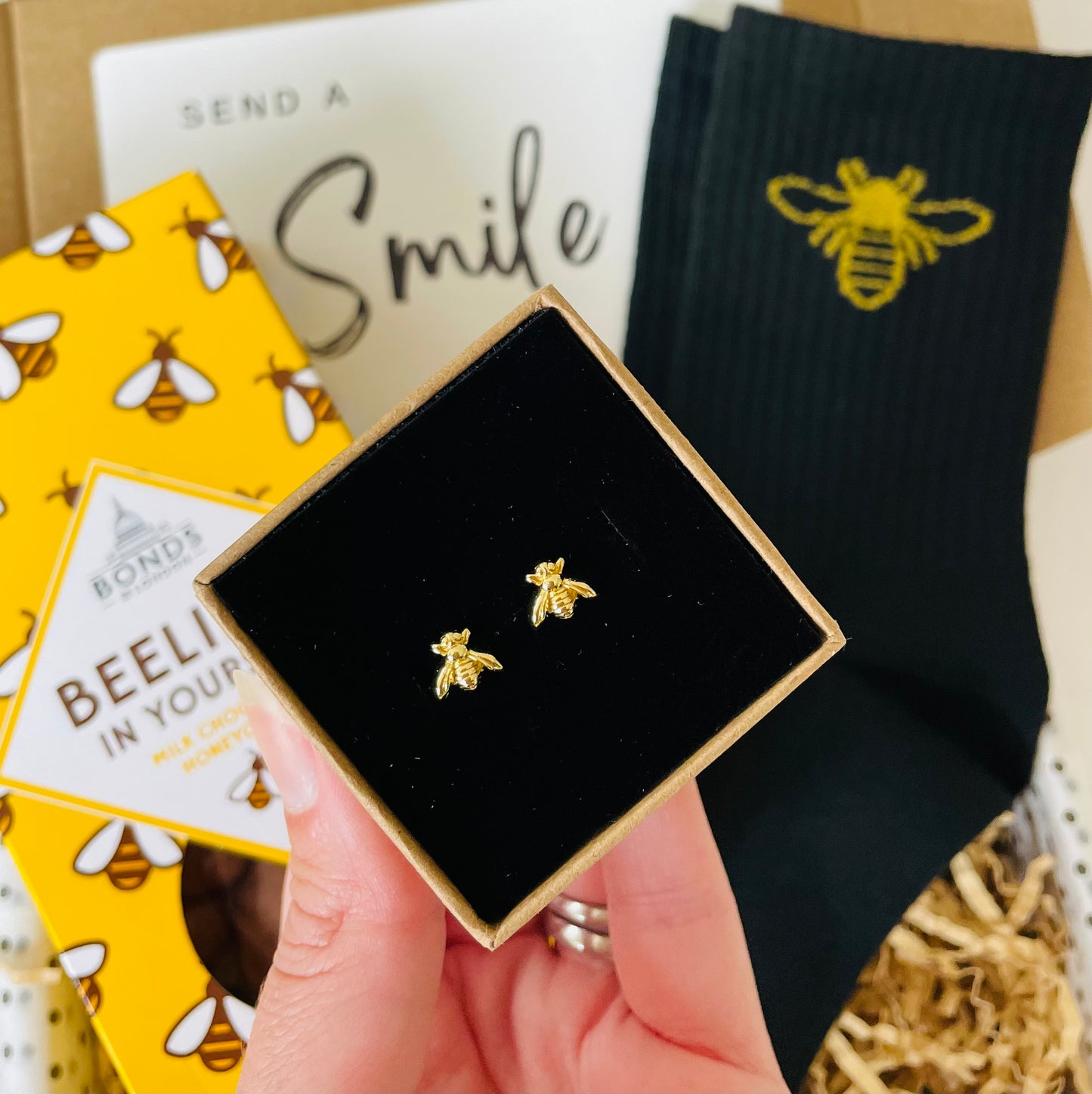 Gold bee earrings in a decorative box
