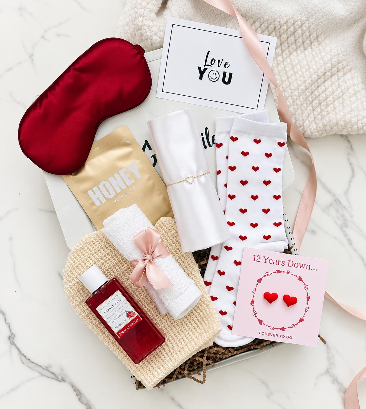 12th wedding anniversary gift hamper for her with silky pillowcase, sleep mask, two silk hearts on a keepsake card, heart socks and pamper treats