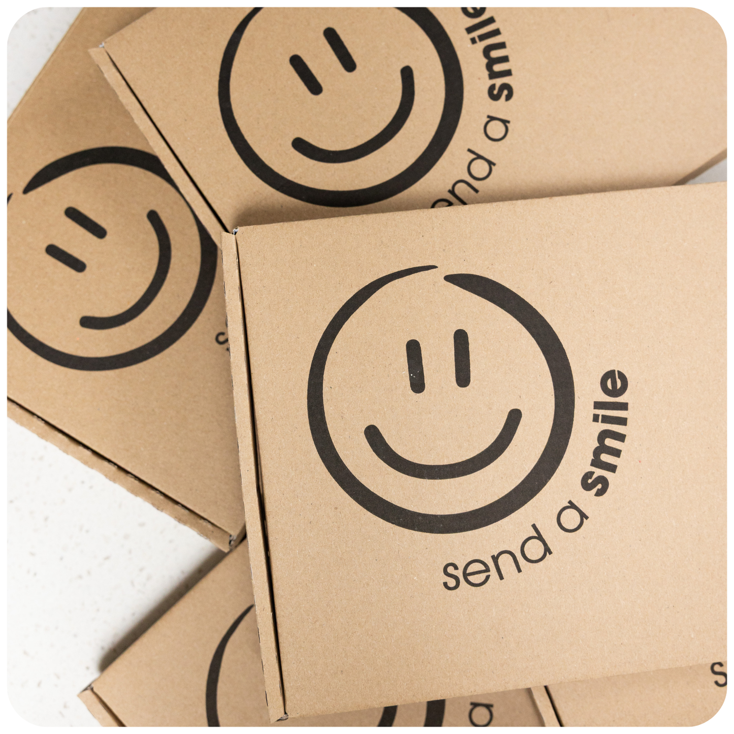 Kraft paper boxes with smiley face design and 'send a smile' text on a white background