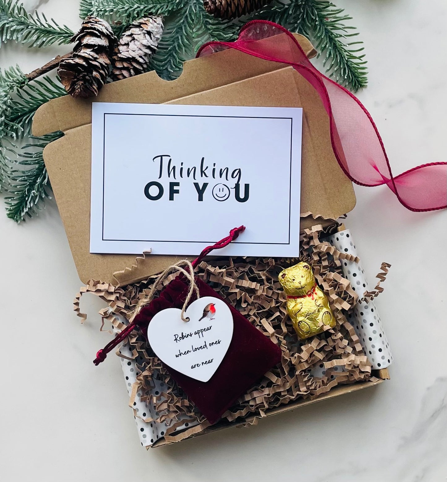 Christmas Robin remembrance gift box featuring a hanging heart keepsake decoration with the saying “Robins appear when loved ones are near,” presented in a velvet pouch with a Lindt gold bear. A thoughtful Christmas sympathy or memorial gift to bring comfort and love during the festive season.